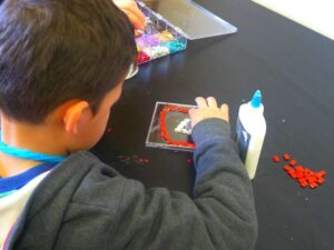 A student crafting a CD case mosaic