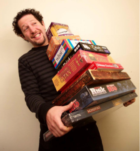 Ryan Dyment, co-founder of the Toronto Tool Library, holds board games from the Sharing Depot's Games Section. (Image: The Sharing Depot)