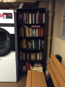 Little free library on repurposed bookshelf in basement of Manhattan apartment building