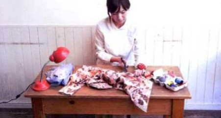 Japanese woman turning a used kimono into new household articles, following a cultural tradition called mottainai.